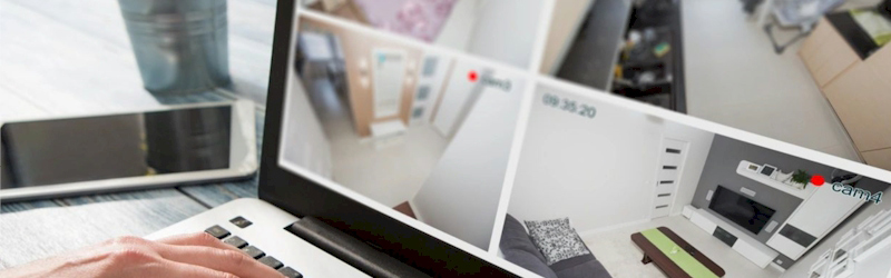Laptop screen displaying multiple live security camera feeds, representing surveillance and monitoring systems