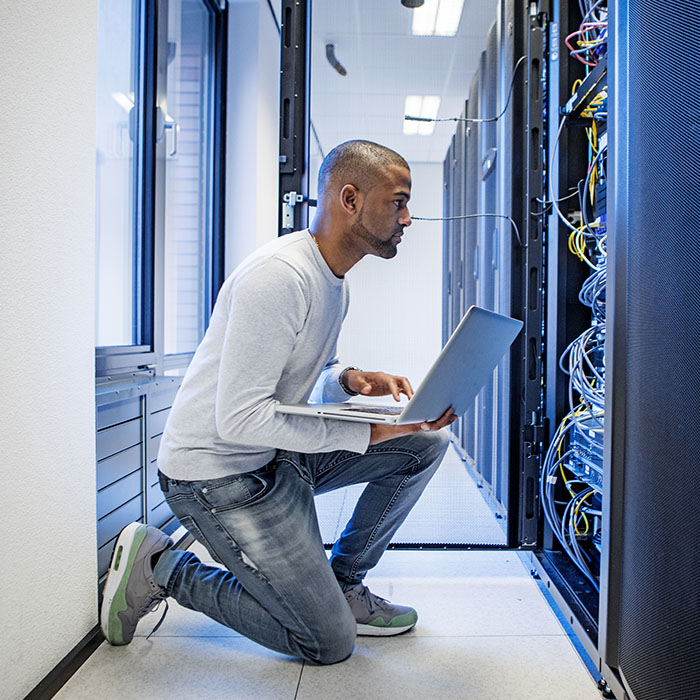 Server technician working back at the office and server room after lockdown