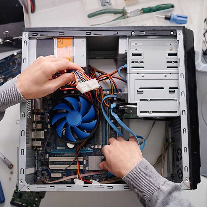 Repairman arranging wires in disassembled system unit of computer