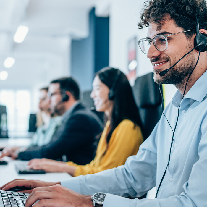 Call center agent working with his colleagues in modern office
