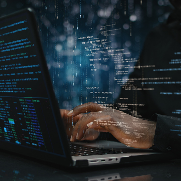 Hands of male sitting in front of computer, focused on developing code
